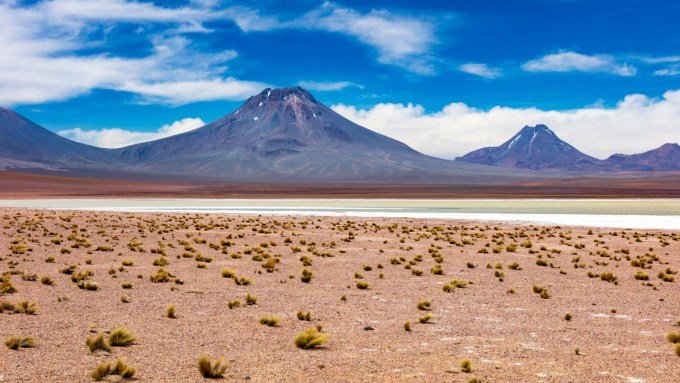 A photo of Lejía Lake with the volcanoes Aguas Calientes and Acamarachi in the background.