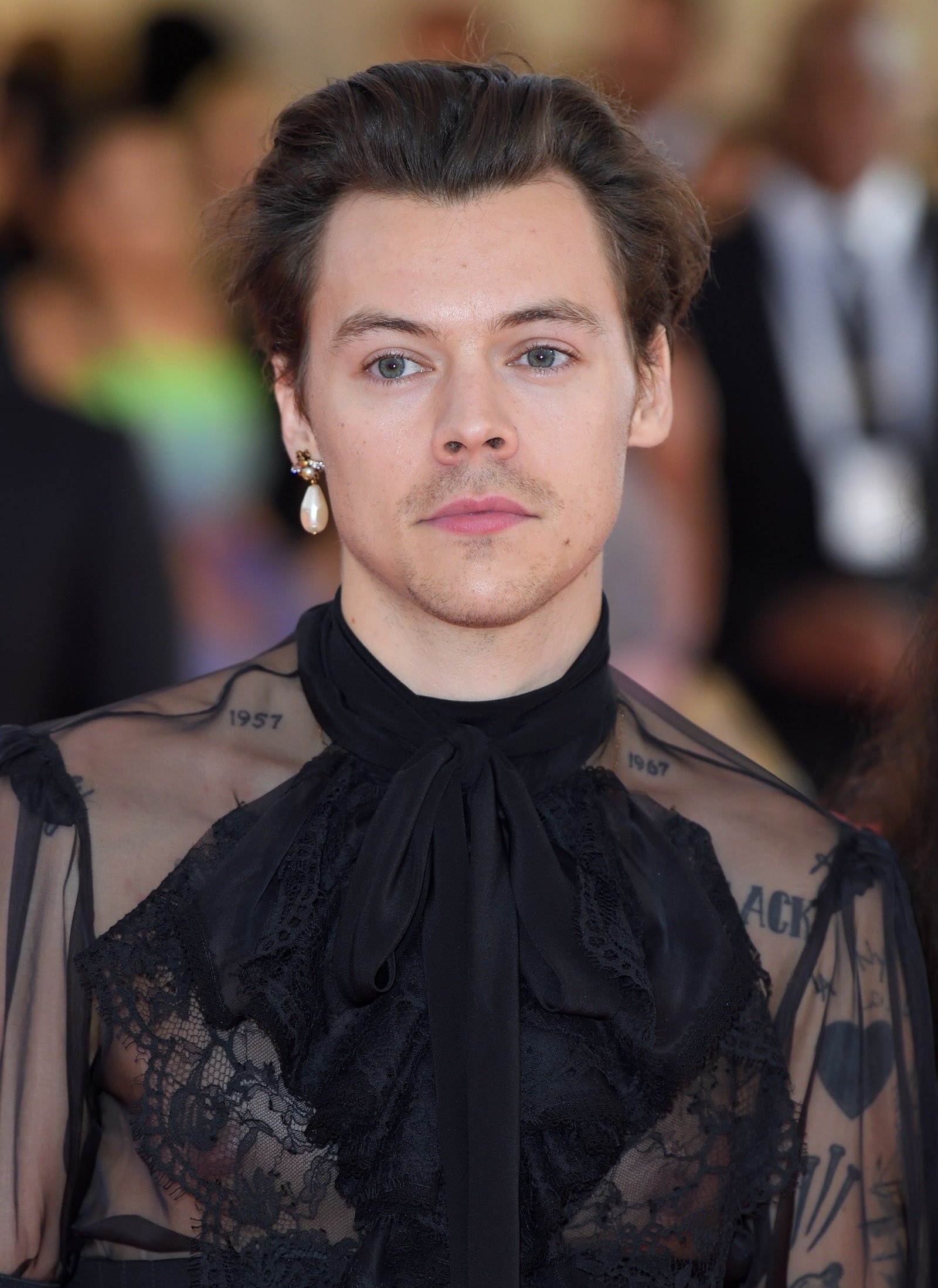 Image may contain Harry Styles Adult Person Face Head Photography Portrait Black Hair Hair and Accessories